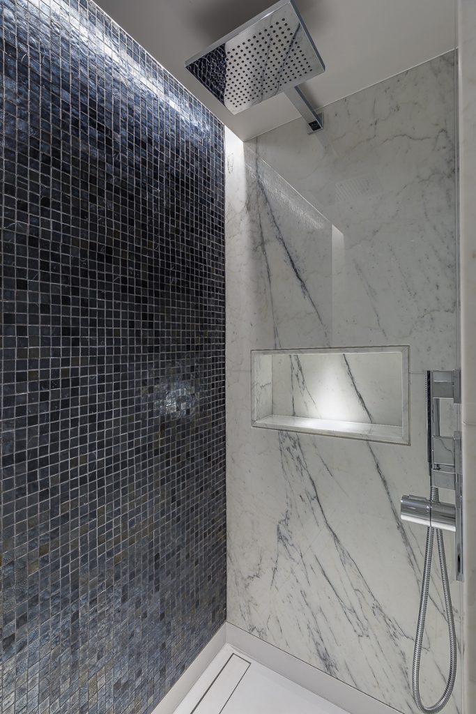 A shower in Statuario Venatino marble panels with a niche lined in Bisazza mosaic — Cornwall Terrace, Roma Marble