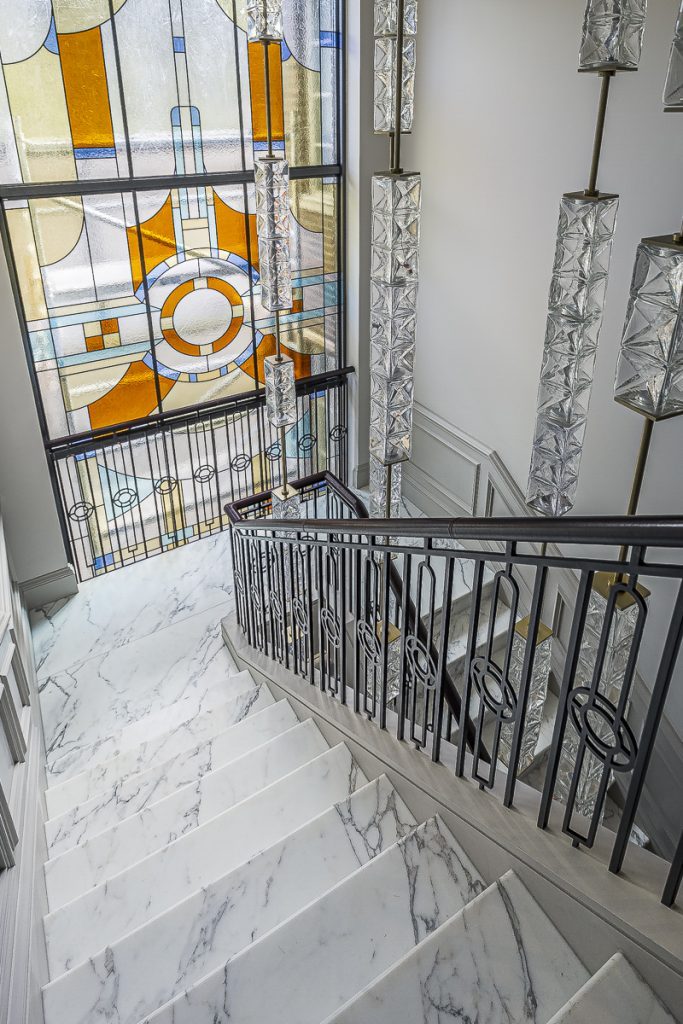 A Calacatta Oro staircase, cut so the veining runs continuously step to step — Ranulf Road, Roma Marble