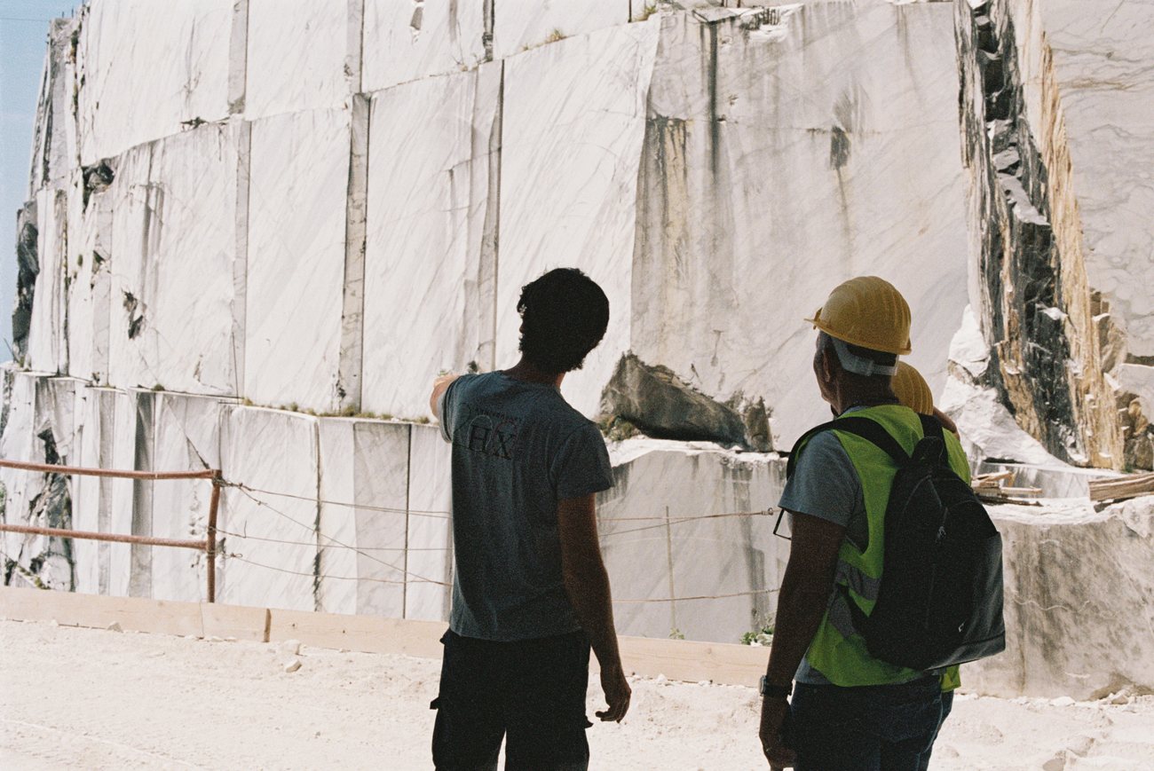 Inspecting a freshly cut marble quarry face in Italy