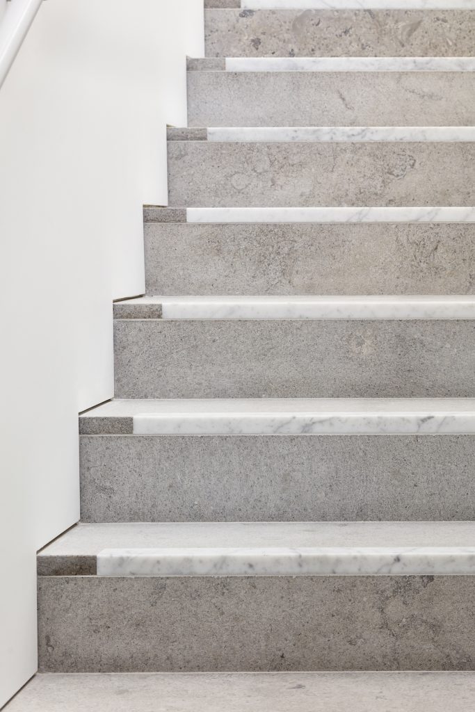 Carrara marble treads paired with Gascoigne Beige risers on the staircase between floors — Mayfair Art Gallery, Roma Marble