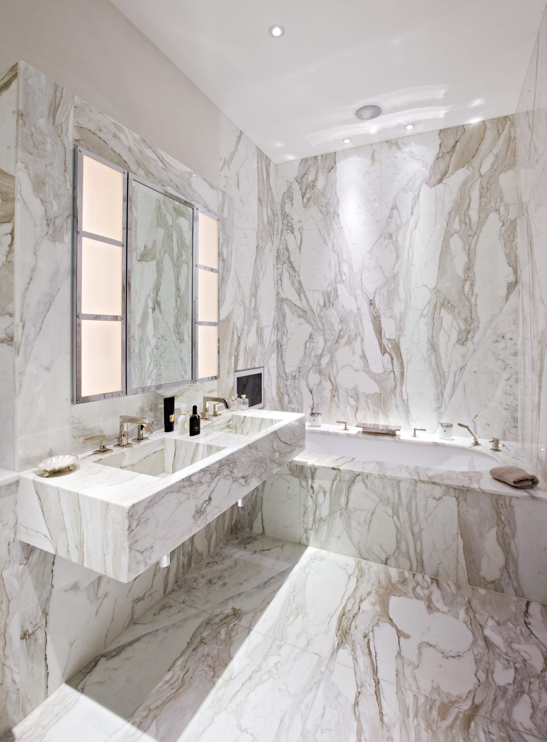 Calacatta Oro's bold veining carried across the bathroom walls and shower — Mayfair, Roma Marble