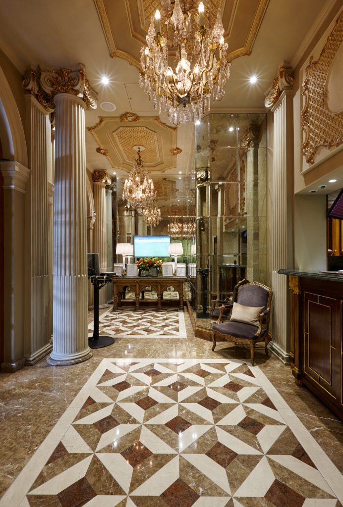 Light Emperador, Dark Emperador and Crema Marfil continue through reception and the bar — Les Ambassadeurs, Roma Marble