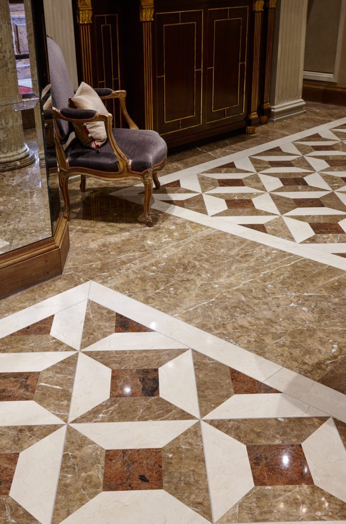 The entrance hall's waterjet-cut floor, combining Light Emperador — Les Ambassadeurs, Roma Marble