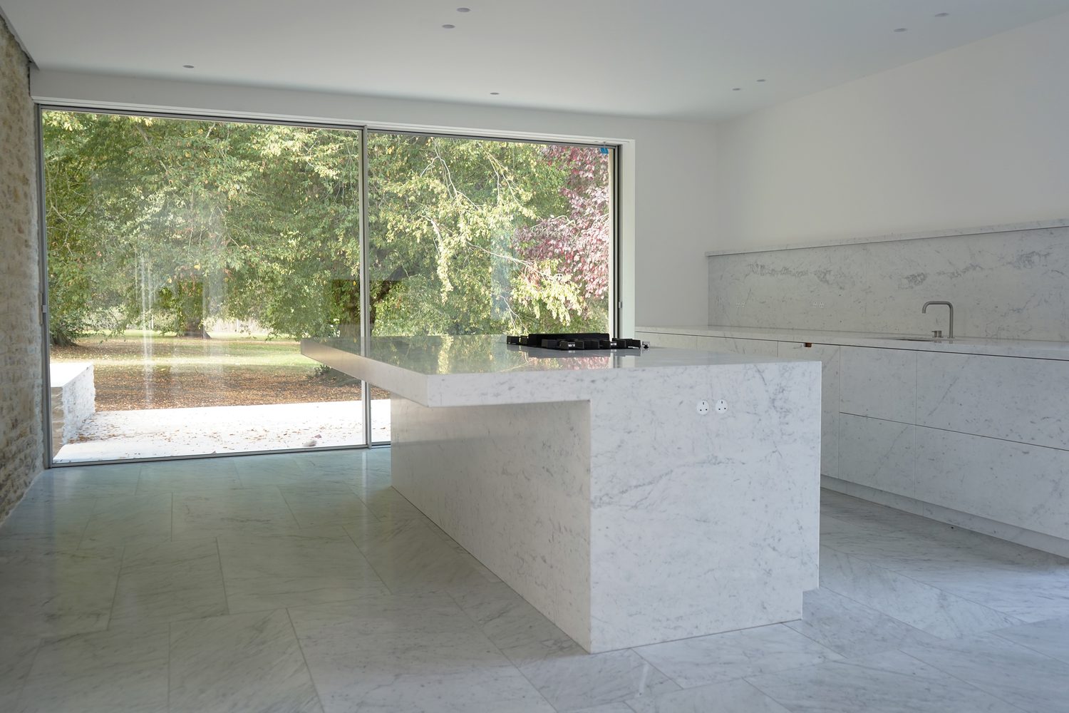 A Carrara marble kitchen island open to the garden, Oxford - Roma Marble