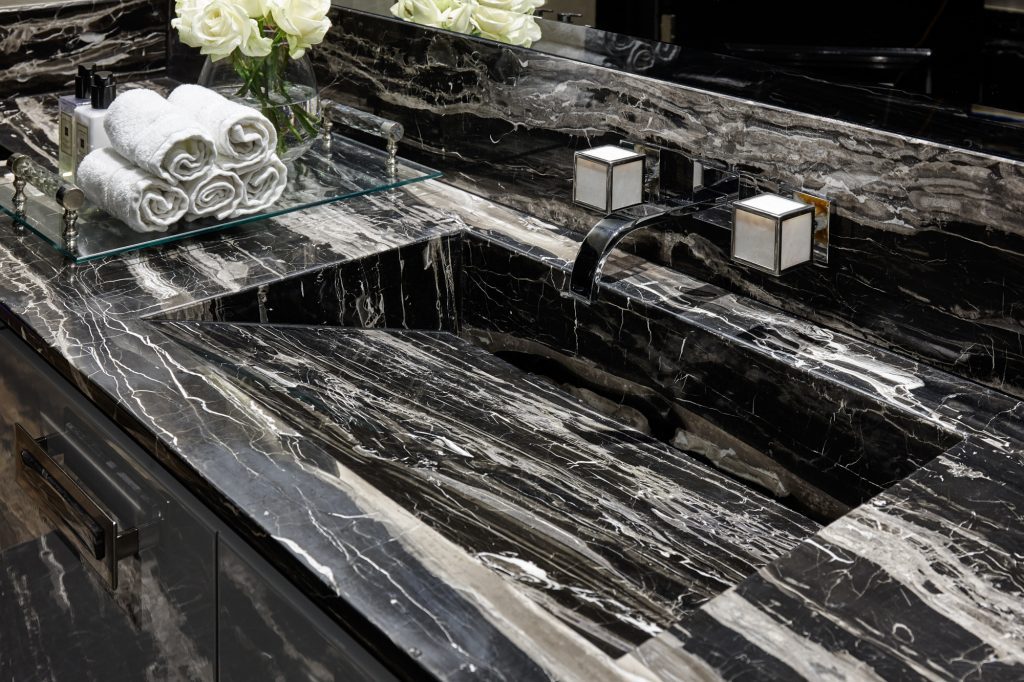 A Cappuccino marble border and skirting frames a Rene Beige limestone floor — Cloak House, Roma Marble