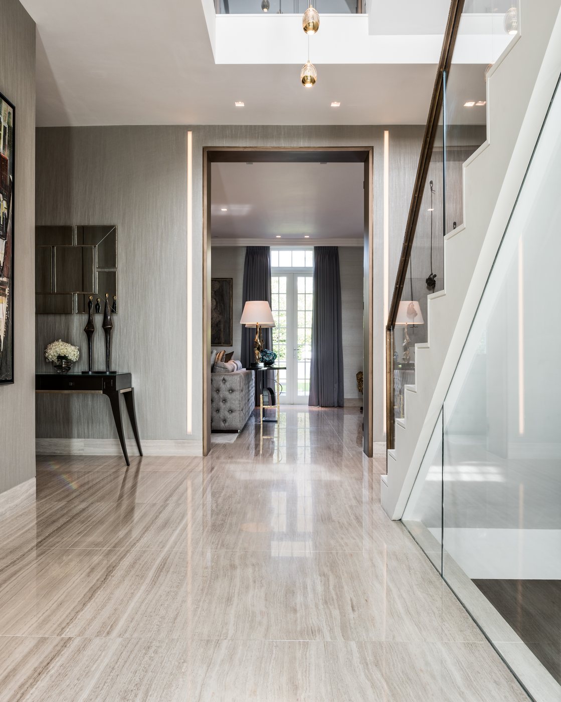 The entrance hall in stone flooring, beneath a double-height ceiling — Winnington Road, Roma Marble